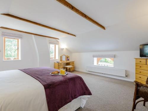 a bedroom with a large bed and a tv at The Coach House in Upwell