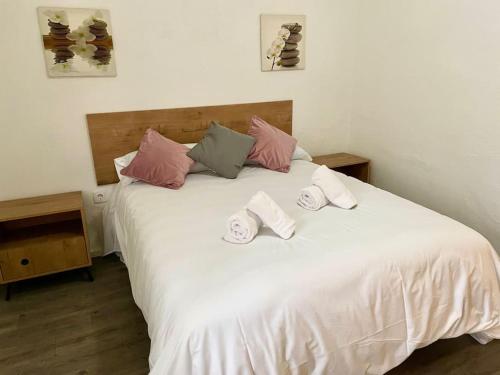 a white bed with three pillows on top of it at Apartamento El Rincón de la Verdad in Córdoba