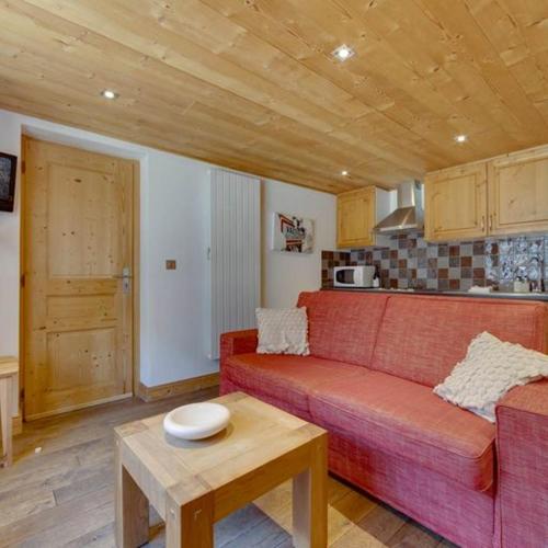 un salon avec un canapé rouge et une table dans l'établissement Le Loup du Laisinant, à Le Fornet