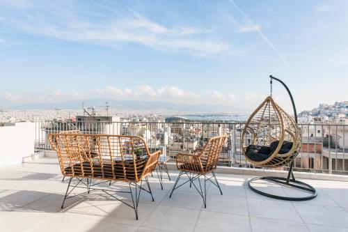 eine Terrasse mit Stühlen und einer Schaukel auf dem Dach in der Unterkunft WYZ Piraeus in Piräus