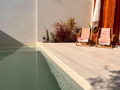 two chairs sitting next to a pool of water at CASA DOS OLIVAIS in Porto