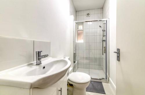 een badkamer met een wastafel, een toilet en een douche bij A beautiful newly renovated home: The Arlingford in Londen