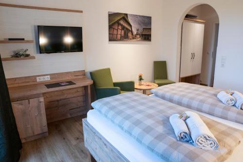 a hotel room with two beds and a television at Hotel Am Deich in Apen