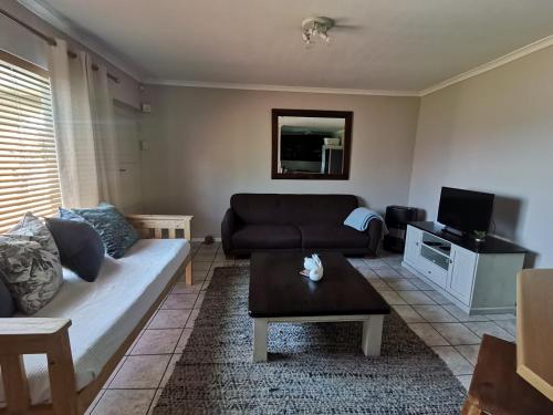 a living room with a couch and a tv at Villa De Vie Self Catering Apartment in Brackenfell