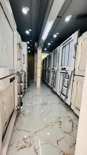 a large room with a marble floor and a hallway with white machines at Astropods in Mumbai