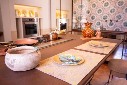 a kitchen with a table with plates on it at Palazzo Maresgallo Suites & SPA in Lecce