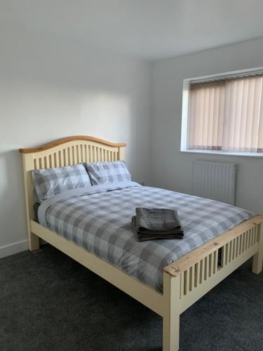 a bed with a wooden frame in a bedroom at Campion Place in Sheffield