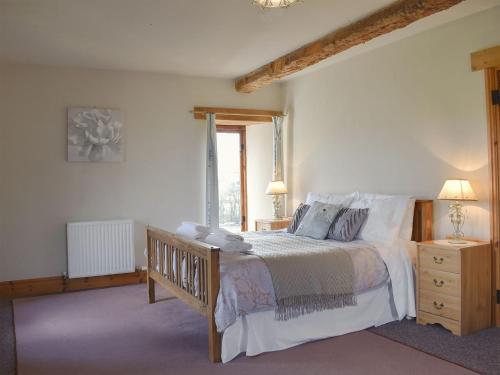 a bedroom with a large bed and a window at Foxcote New Court Farm in Marstow