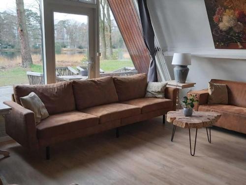 - un salon avec un canapé brun et une table dans l'établissement Alluring Holiday Home in Stramproy with Private Terrace, à Stramproy