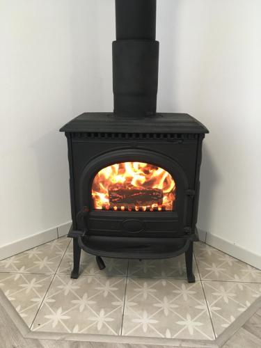 a black stove with a fire in a room at Apartmány U Hadiny in Humpolec