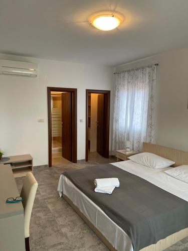 a bedroom with a large bed with a white towel on it at Villa Magnolia in Privlaka