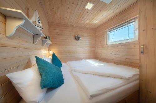 a small room with two beds in a wooden room at Hausboot Lasse in Heiligenhafen