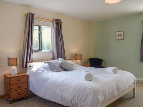 a bedroom with a large white bed and a window at Hill View Lodge in Knucklas