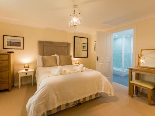 a bedroom with a large bed with two towels on it at 13 Great Cliff in Dawlish
