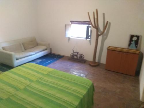a living room with a bed and a couch at Casa alma verde alegria in Luyaba