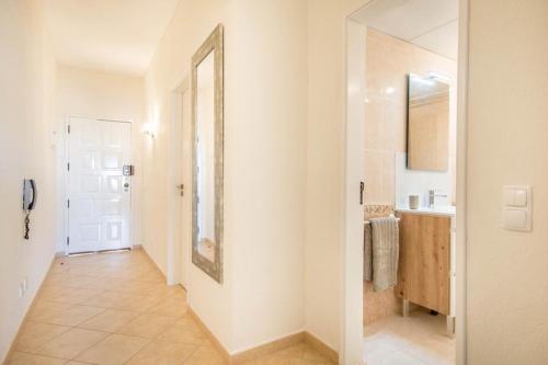 um corredor de uma casa de banho com um espelho e um lavatório em Albufeira Holidays Near The Strip em Albufeira