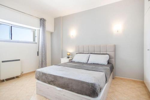 a bedroom with a large bed and a window at Albufeira Holidays Near The Strip in Albufeira