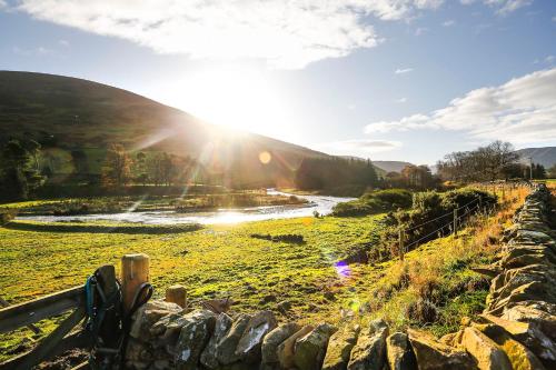 a view of the sun setting over a field at Castlehill cabin with a hot tub in Peebles