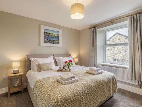 a bedroom with a bed with towels on it at Lane Ends Cottage in Disley