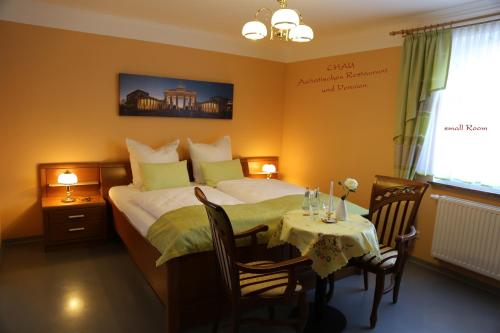 una habitación de hotel con una cama y una mesa con una mesa en Chau-Asiatisches-Restaurant und Pension en Rüdersdorf