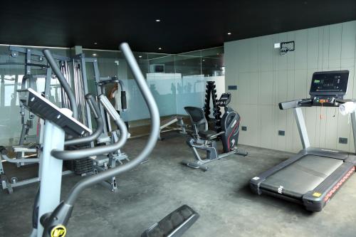 a gym with several exercise bikes and a treadmill at Crystal Suites in Badagara
