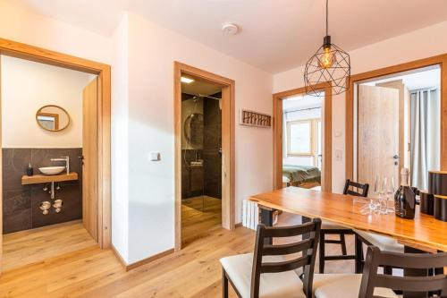 a dining room and kitchen with a wooden table and chairs at Tiroli in Westendorf