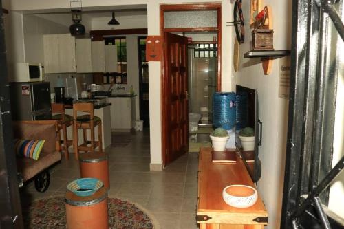 a living room with a table and a kitchen at Vintage@HeArt Stays in Kakamega