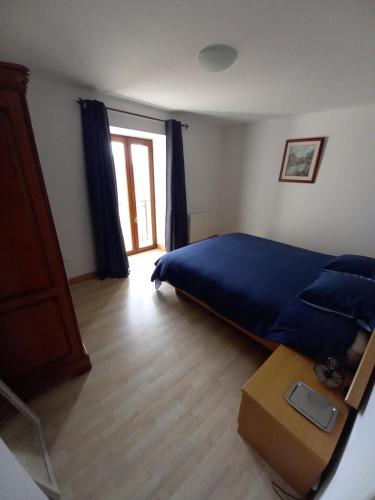 a bedroom with a blue bed and a wooden floor at Chambre d'hôtes Saumur-Champigny 2 personnes in Montreuil-Bellay