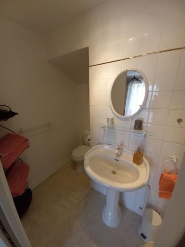 a white bathroom with a sink and a mirror at Chambre d'hôtes Saumur-Champigny 2 personnes in Montreuil-Bellay