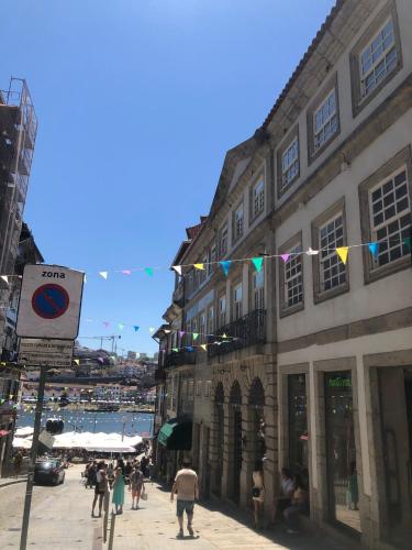 a group of people walking down a street next to a building at Oca Ribeira do Porto AT in Porto