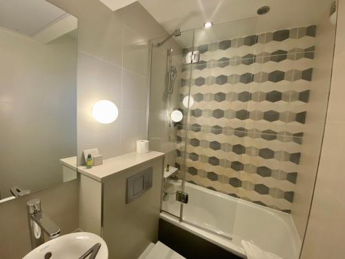 a bathroom with a shower and a toilet and a sink at Hotel Yllen Eiffel in Paris