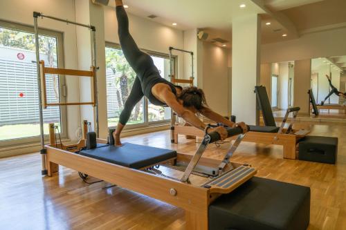 a woman doing a handstand on a pilates reformer at Lara Barut Collection-Ultra All Inclusive in Lara