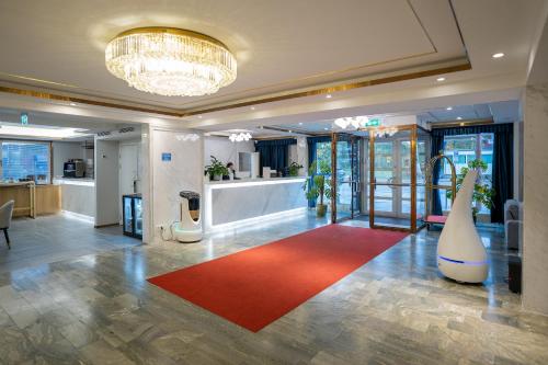 ストックホルムにあるLivington Hotelの赤い敷物が敷かれた広い部屋があるロビー