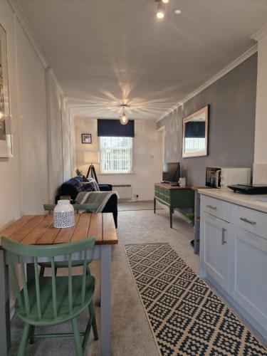 eine Küche und ein Wohnzimmer mit einem Tisch und einem Sofa in der Unterkunft Small Cottage close to Carbis Bay Beach & St Ives in Carbis Bay