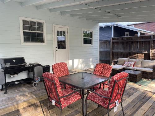 a patio with a table and chairs and a couch at Updated Red Door Revival in Downtown Saint Augustine in Saint Augustine