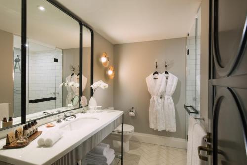 uma casa de banho com um lavatório e um espelho em Mayfair Hotel em Adelaide