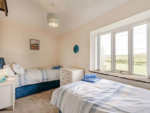 a bedroom with two beds and a window at Middle Bank Top Farm - Uk39183 in Rossendale