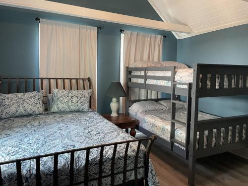 a bedroom with two bunk beds and blue walls at Updated Red Door Revival in Downtown Saint Augustine in Saint Augustine