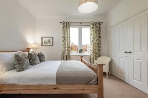1 dormitorio con cama y ventana en Heather Cottage, 2 bedroom in Comrie, en Comrie