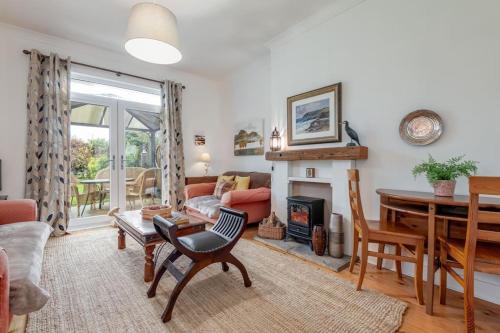 a living room with a table and a fireplace at Heather Cottage, 2 bedroom in Comrie in Comrie