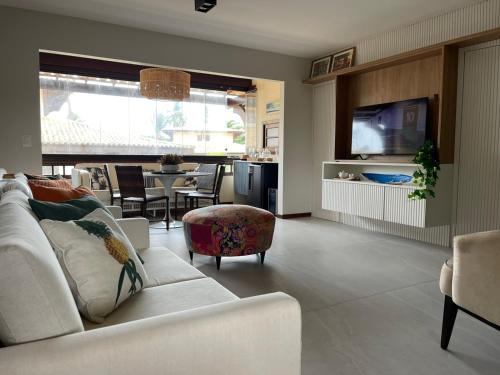 salon z białą kanapą i telewizorem w obiekcie Praia do Forte Condomínio Bali Bahia Apt105 w mieście Praia do Forte