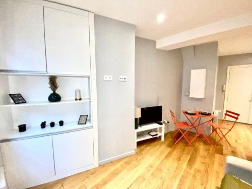 - un salon avec des armoires blanches et une table dans l'établissement Vaugirard - Saint Germain des Prés - Best Place, à Paris