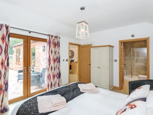 a bedroom with a bed and a sliding glass door at Nesting Box in Chapel Saint Leonards