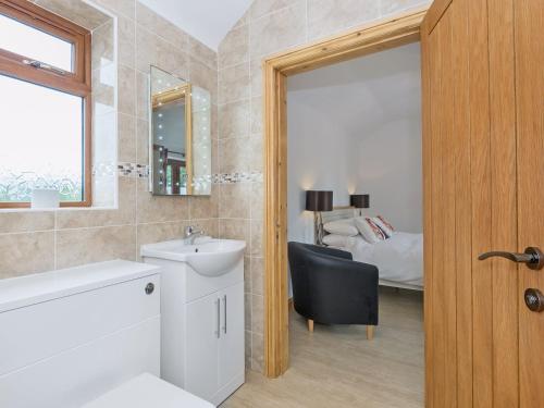 a bathroom with a sink and a mirror and a bed at Nesting Box in Chapel Saint Leonards