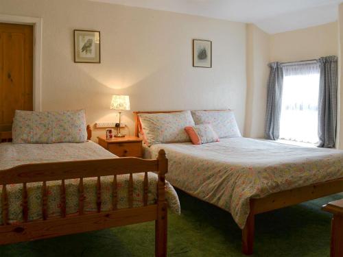 1 dormitorio con 2 camas y ventana en The Bridge Inn Apartment en Bridgerule