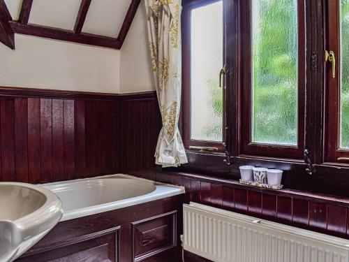 baño con bañera y ventana en Heritage Lodge, en Rhyl