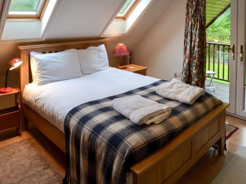 a bedroom with a bed with two towels on it at The Anchorage in Wroxham