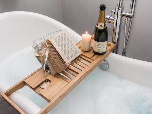 a drink tray with a bottle of wine and a candle at The Old Hall Coach House in Ashwellthorpe