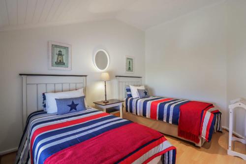 a bedroom with two beds and a table with a lamp at 128 @ The Dunes in Plettenberg Bay