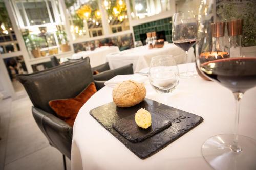 - une table avec une assiette de fromage et des verres à vin dans l'établissement Gilpin Hotel & Lake House, à Bowness-on-Windermere